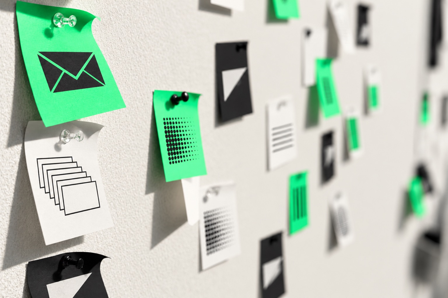 Green, black and white notes pinned to a planning wall